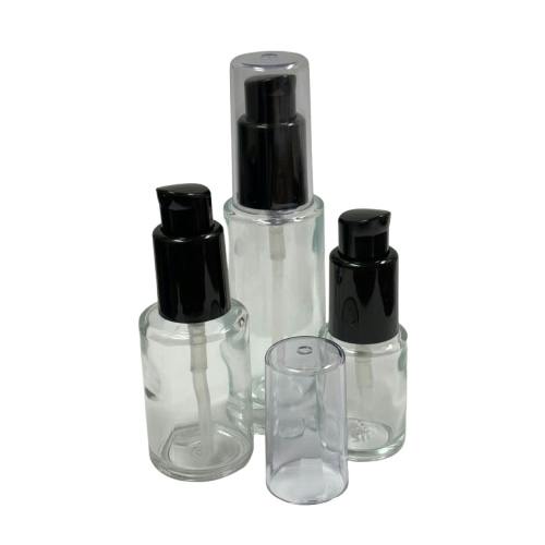 30mL (1 oz.) Clear Tall Cylinder Glass Bottle with 18/415 Black Polypropylene Denali Treatment Pump with Tall Smooth Collar & Clear ABS Overcap